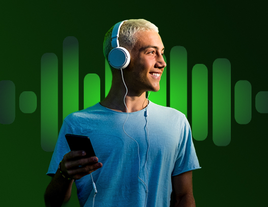 Młody, uśmiechnięty chłopak otworzył konto osobiste w UniCredit i słucha muzyki na słuchawkach poprzez Spotify Premium.