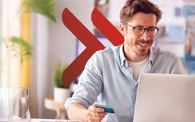 Młody mężczyzna dokonujący płatności online kartą dla firm UniCredit.